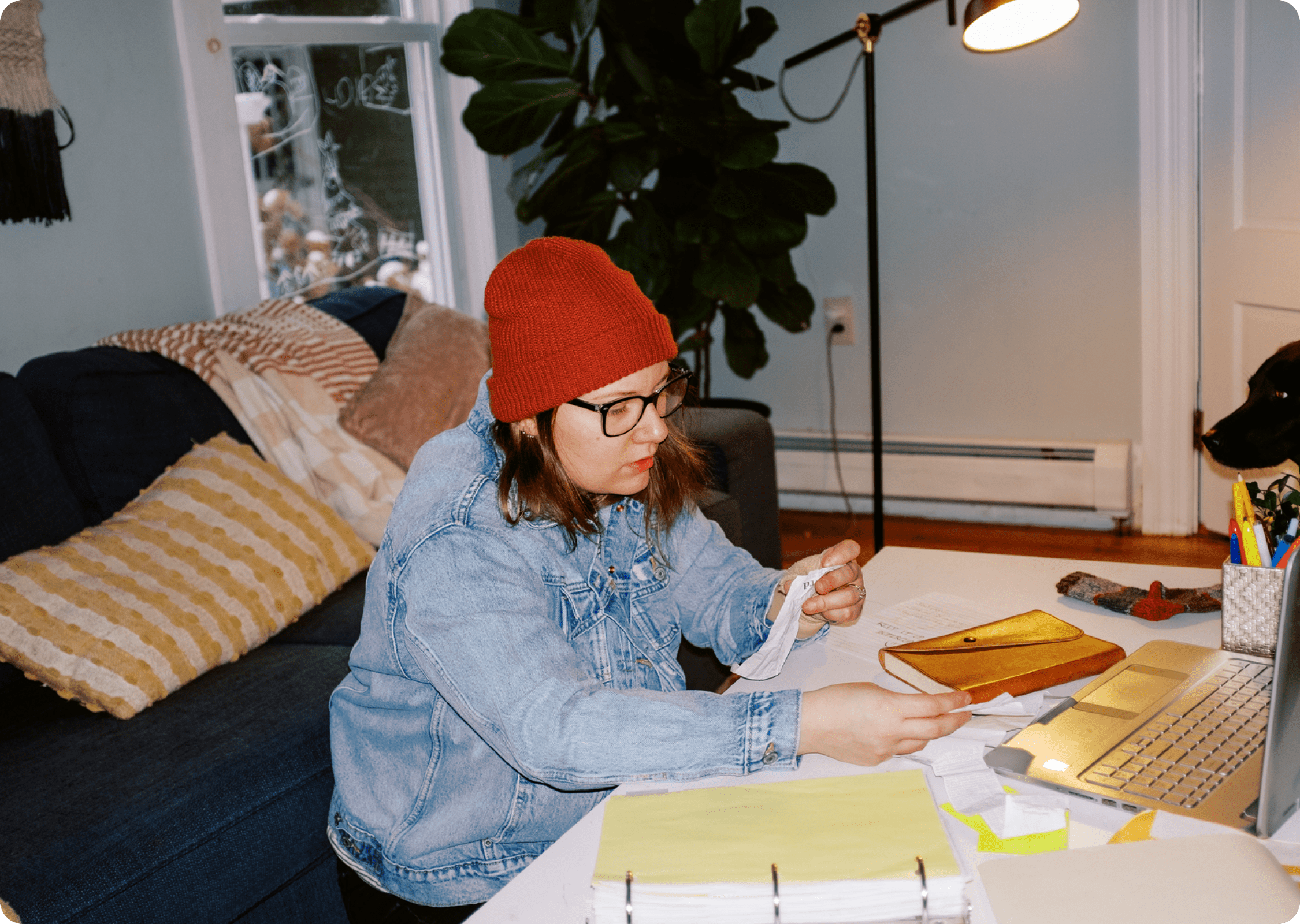 Renter reviewing bills and paperwork at home while working on a laptop.
